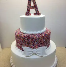 A white cake with the letter "A" on top of it