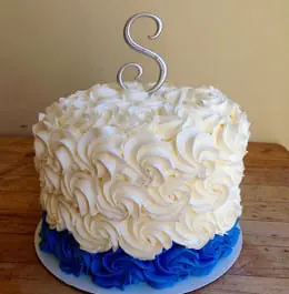 A wedding cake made of white and blue waves of frosting