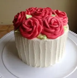 A cake with red roses made of frosting