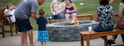 Family sitting around a fire roasting S'mores